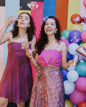 Dos amigas soplando pompas en la segunda toma de la misma tira